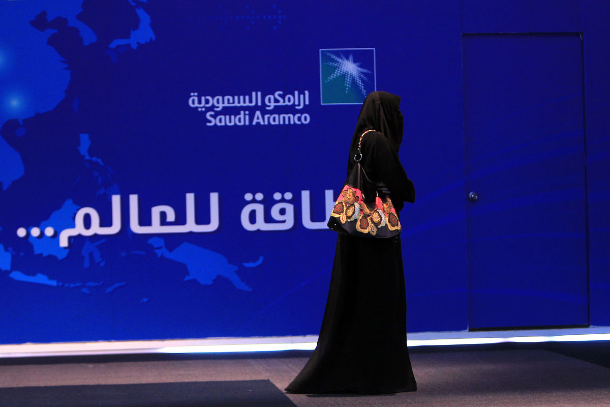 saudi woman in niqab walks past saudiaramco