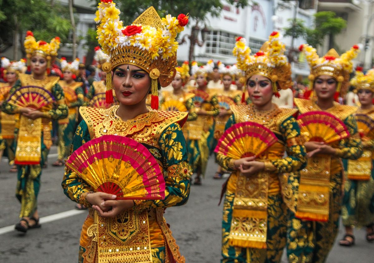  Indonesian women in traditional Balinese dance costumes perform a traditional Balinese dance in a parade.